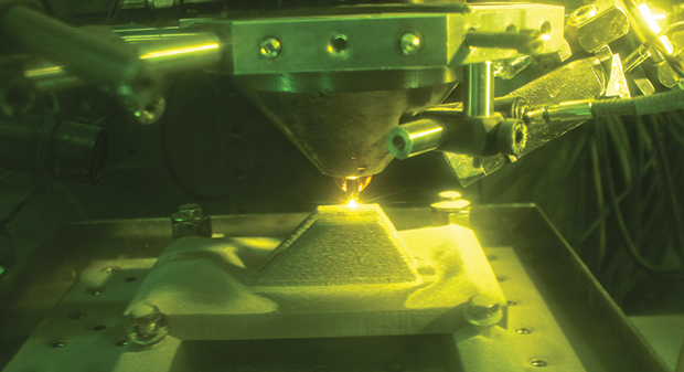 Fabricating a MV-22B nacelle link inside a directed energy deposition 3D printer. Photo via NAVAIR.