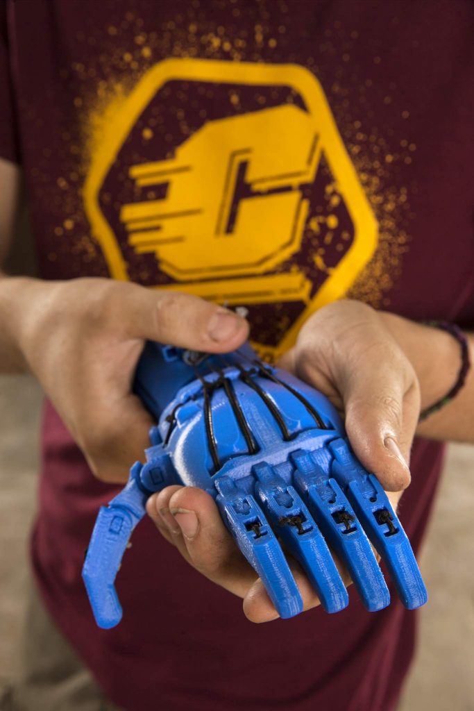 CMU engineering student Austin Brittain holds a prototype of a 3D printed hand he made. Central Michigan University photos by Steve Jessmore