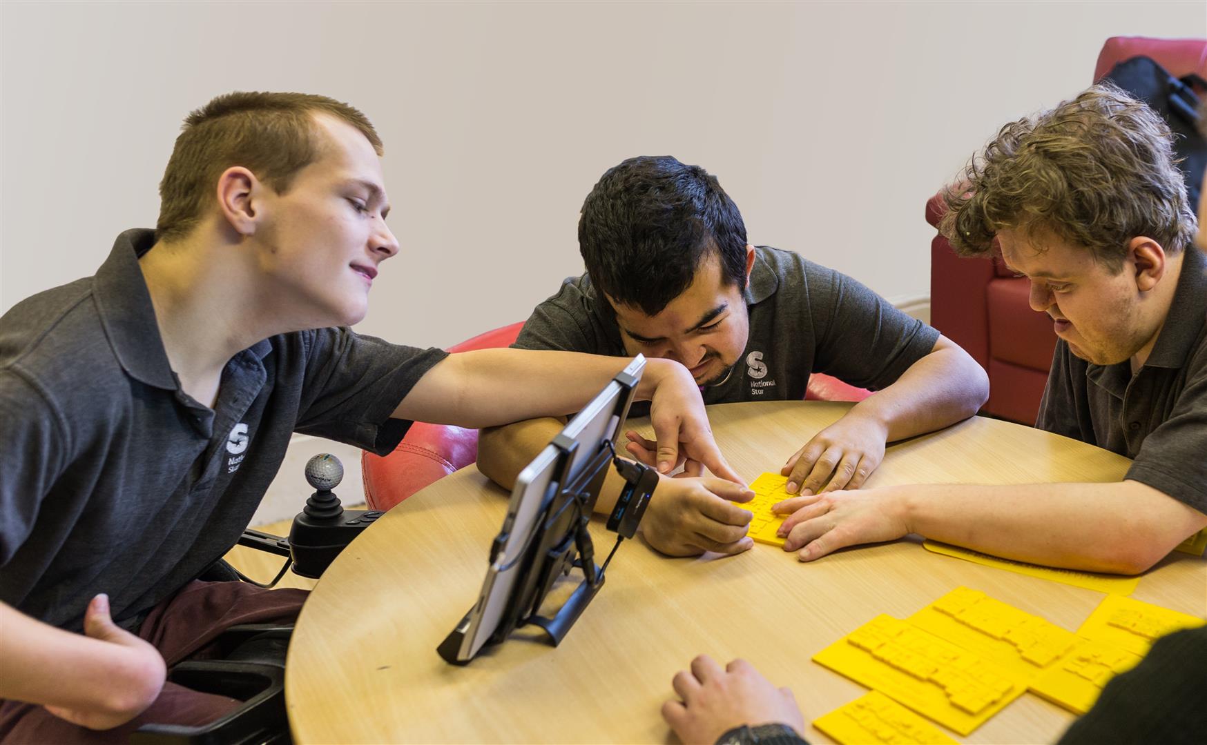 Blind student Elliot (centre) and his yellow 3D printed map. Photo via the National Star.