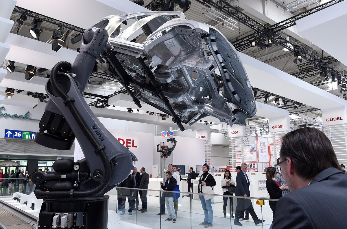 A KUKA robotic arm lifts the body of a car at Hannover Messe 2017. Photo via @hannover_messe on Twitter