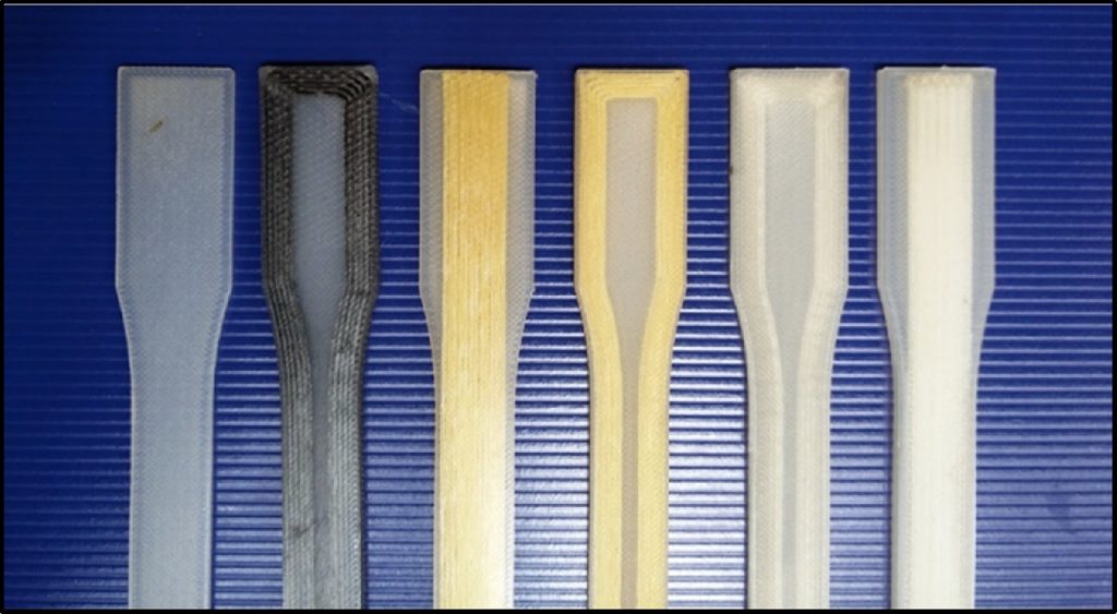 Dog-bone bars 3D printed in a variety of materials. From left to right: Nylon, Carbon A, Kevlar B, Kevlar A, Glass A, Glass B. Photo via Additive Manufacturing vol.16