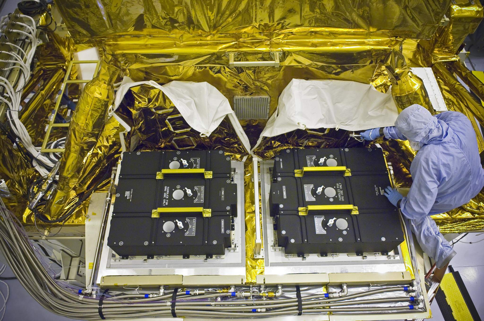 Technicians installing new batteries onto the Hubble Space Telescope. Photo via NASA. 