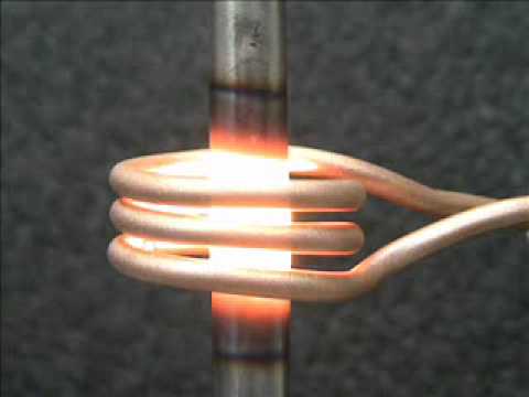 A copper induction coil heating a metal bar. Image via GH Induction. 