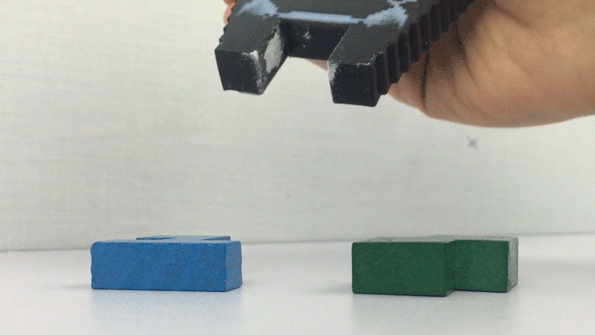 A voxel-optimized soft gripper used to pick up geometric blocks. Gif via MIT News.
