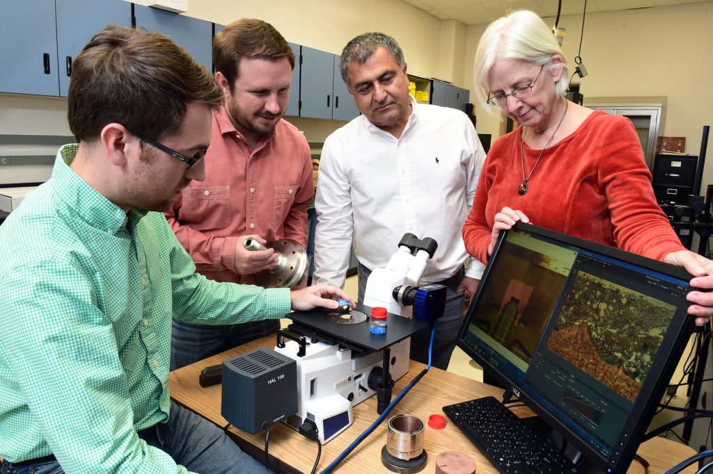 Majid Babai (center) along with Dr. Judy Schneider, mechanical and aerospace engineering professor at the University of Alabama in Huntsville and graduate students Chris Hill and Ryan Anderson examine a cross section of the prototype rocket engine igniter. NASA/MSFC image by Emmett Given