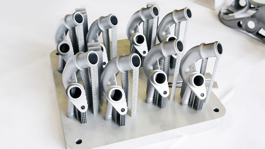 Sample metal 3D printed water connectors for the Audi W12 engine. Photo via Volkswagen AG