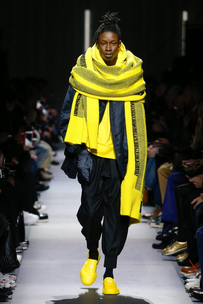 Y-3 Fall 2018 Menswear features huge yellow scarfs. Photo via Photo: Monica Feudi / Indigital.tv.