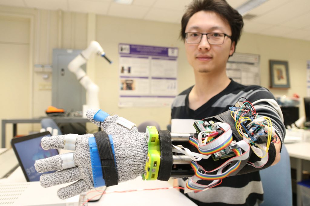 3D printed tremor suppression glove worn by Yue Zhou, a doctoral student at Western University. Photo via Western University.