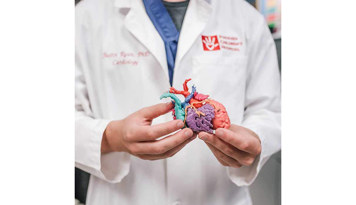 Justin Ryan, Research Scientist at the Cardiac 3D Print Lab, Phoenix Children’s Hospital, holds a 3D printed heart model. Photo via Philips USA.