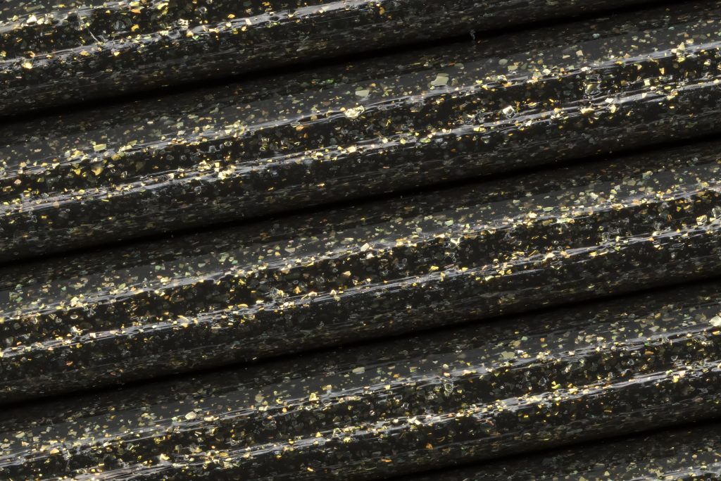 Macro image of gold glitter flecks in Fillamentum’s Vertigo Galaxy Extrafill PLA. Photo by Jason Canning