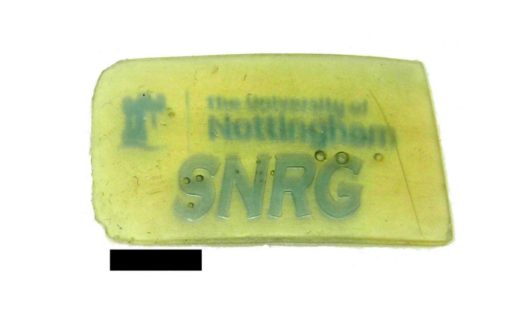 A two color 3D printed sample of the University of Nottingham logo and lab undertaking photochromatic smart material research. Photo via the University of Nottingham