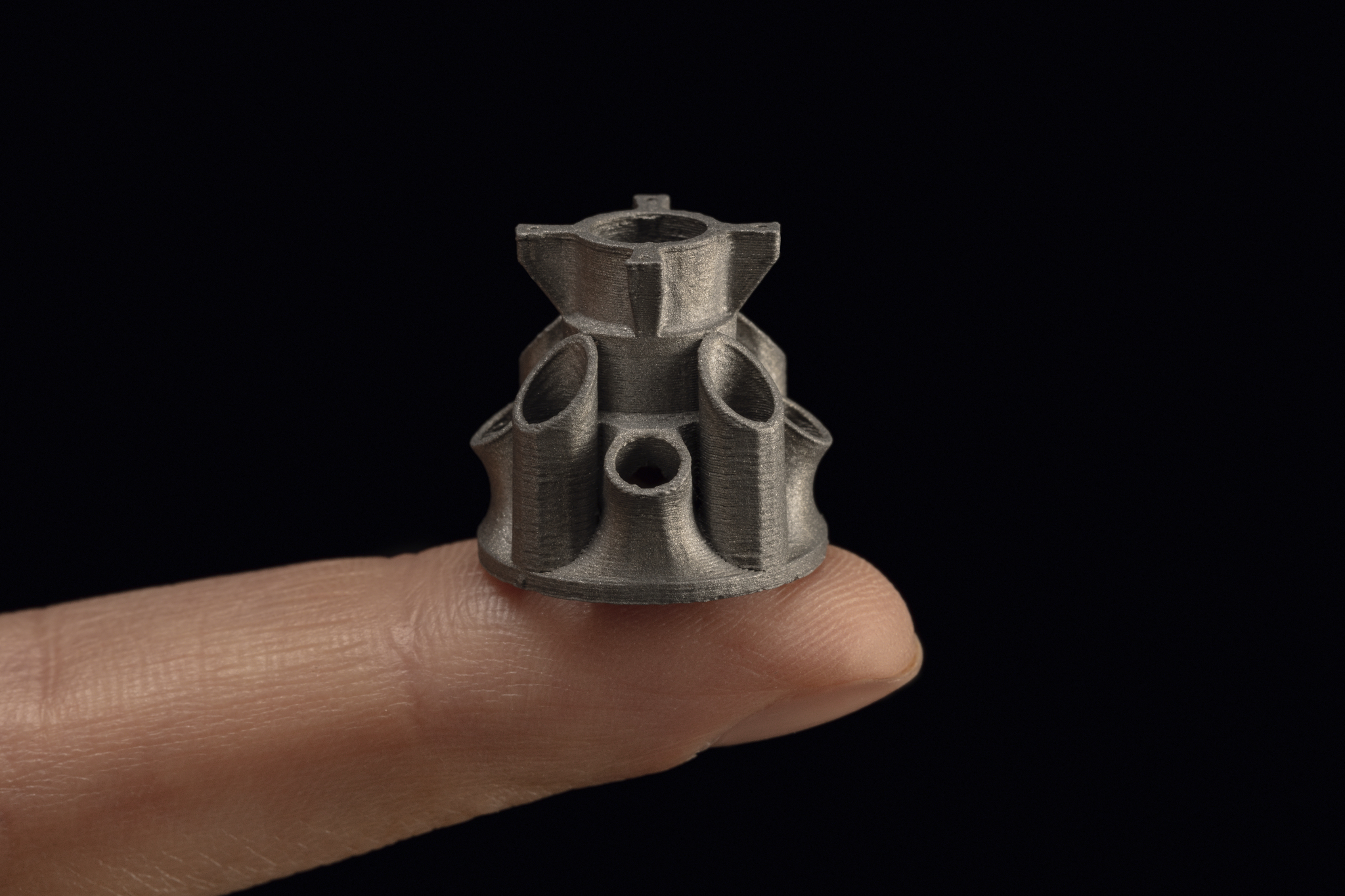 A complex metal part the size of a fingertip 3D printed on the Studio System+. Photo via Desktop Metal.
