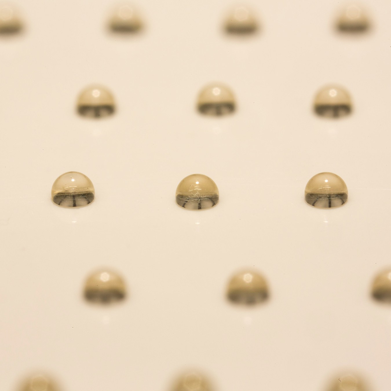 Honey drops patterned on a glass substrate using the controlled acoustophoretic printing head. Photo via Daniele Foresti & Jennifer A. Lewis/Harvard University