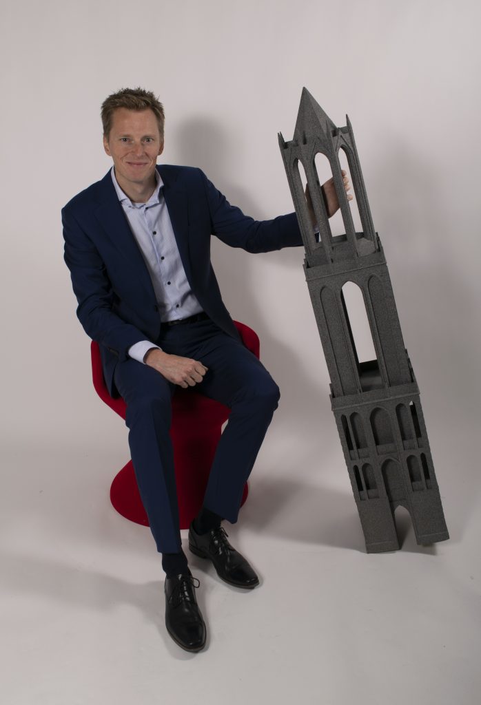 Maurits Blok, Commercial Director of Tractus3D, and a large scale 3D print of a tower. Photo via Tractus3D
