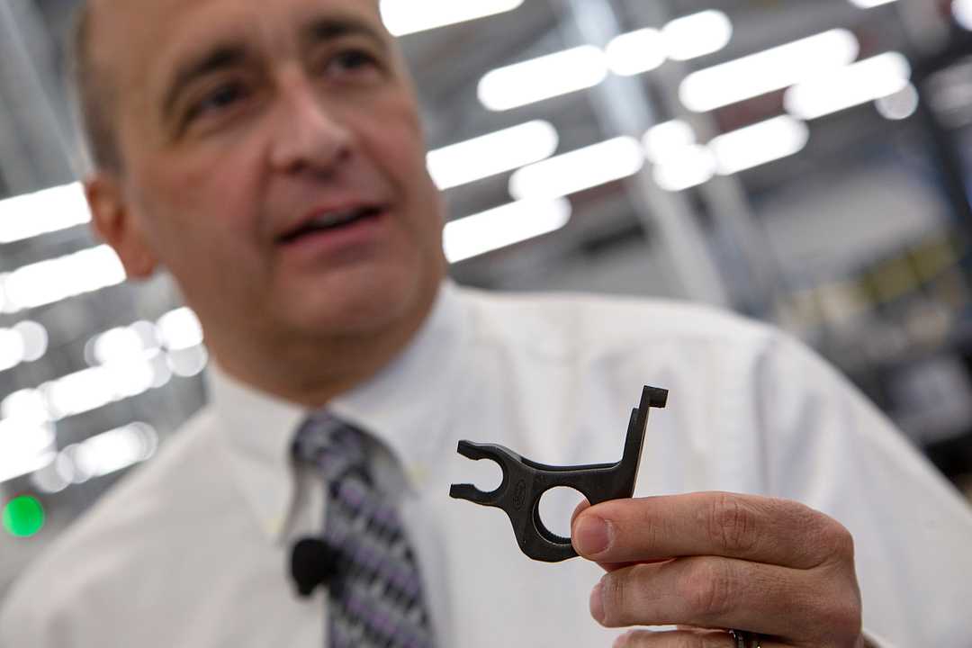 Harold Sears holding the 3D printed brake bracket of the Mustang GT500. Photo courtesy of Mandi Wright, Detroit Free Press