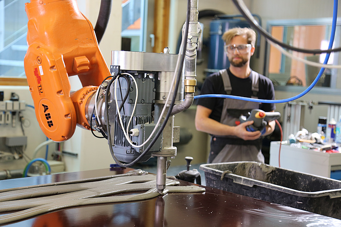 The 3D print head mounted on the robotic arm. Image via TU Graz.