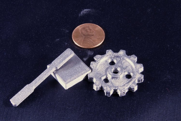 3D printed titanium gear, dogbone, and block. Image via nScypt.
