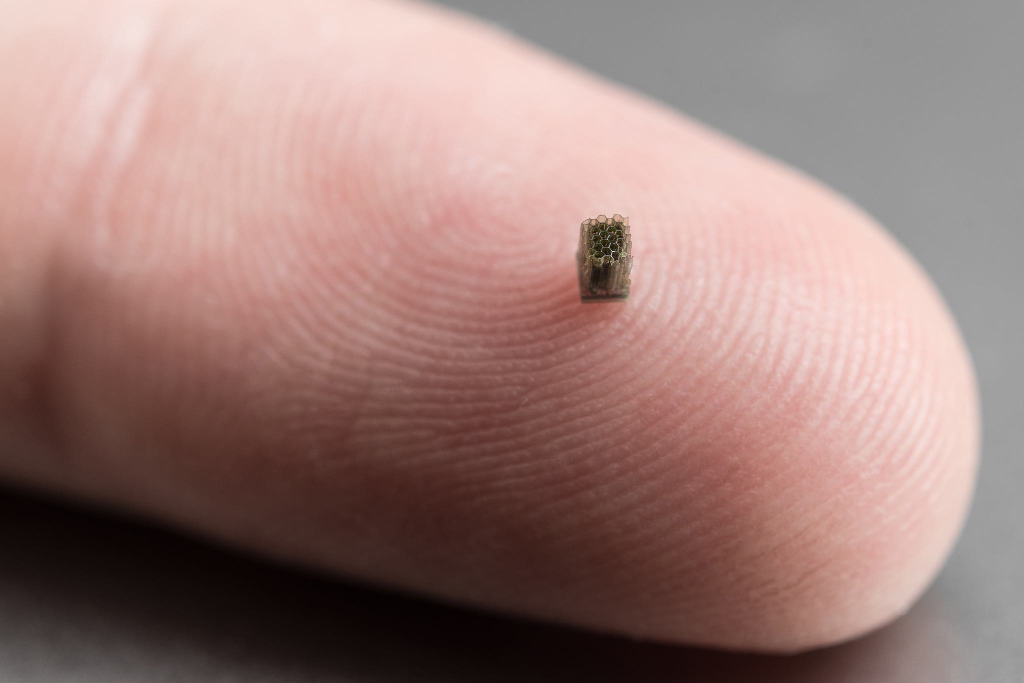 A micro honeycomb structure in PP, with wall thicknesses of ~20 microns over a height of a few mm. The part is made for a company that specializes in micro batteries. The ultra-high surface area is used to increase battery storage with minimal footprint. Part size 1.6 x 1.8 x 2.3 mm3, print time 80 minutes, and print layer 2 microns. Photo via Nanofabrica.