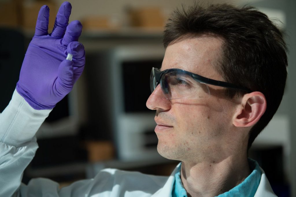 Rice University graduate student Sean Bittner holds a sample of a 3D printed scaffold. Photo by Jeff Fitlow, Rice University