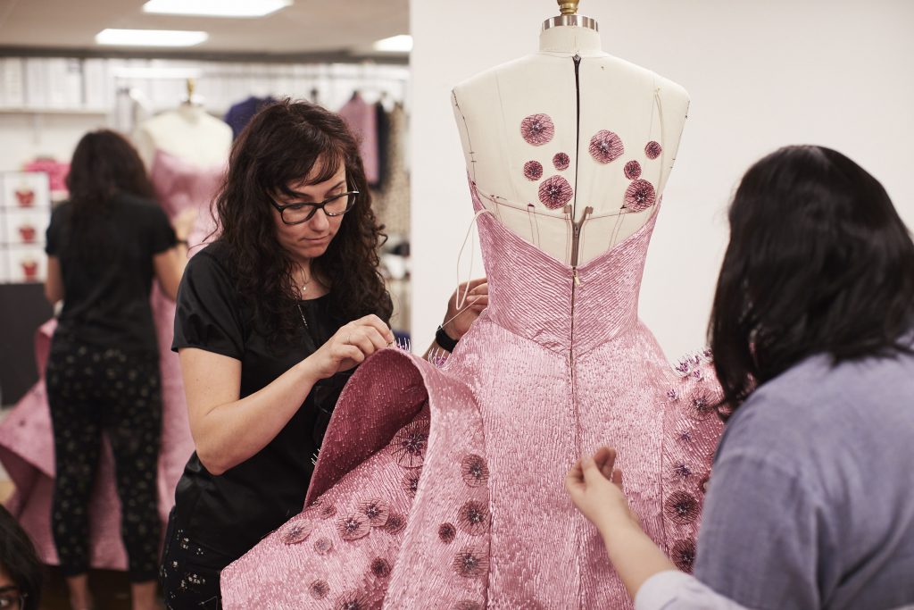Sewing 3D printed embellishments onto Deepika Padukone 2019 Met Gala dress. Photo via Zac Posen x GE Additive x Protolabs