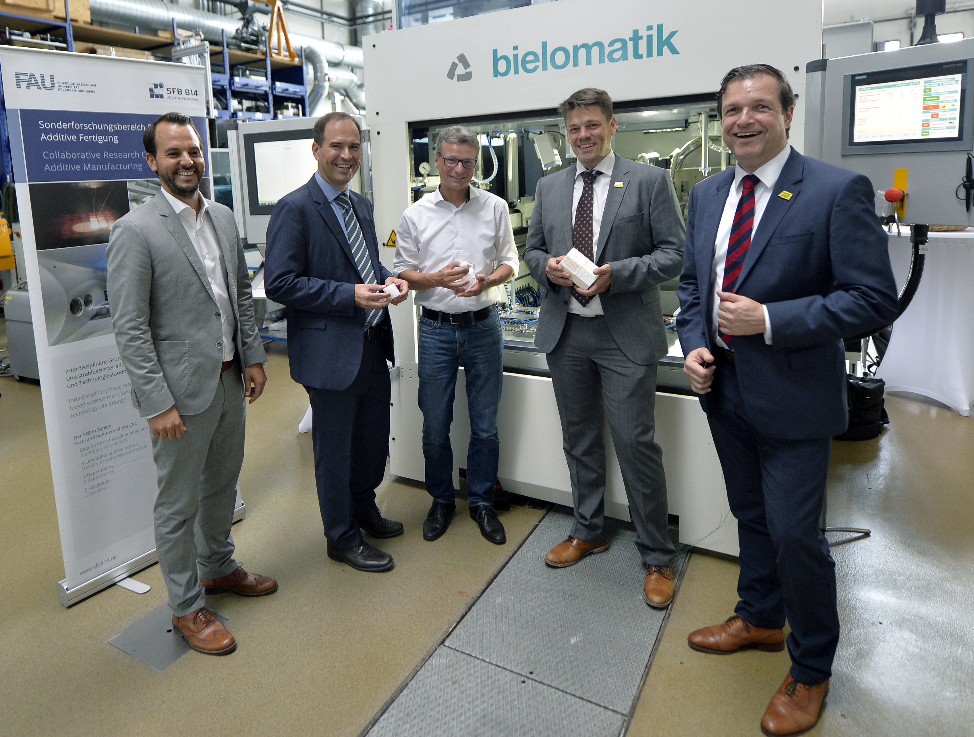 Partners of the FAB-Weld project, from left: Christian Wiesner (FIT Additive Manufacturing Group), Tobias Beiss und Juergen Lochner (bielomatik), Prof. Dr.-Ing. Dietmar Drummer (FAU/LKT), Bavarian Minister of Science Bernd Sibler, Prof. Dr. Arndt Bode and Joachim Hornegger (Bavarian Research Foundation). Photo via FAU/Harald Sippel)