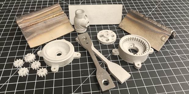 Stainless steel parts produced on a desktop 3D printer, with the back left and right plates having been welded together after printing. Photo via SCC.