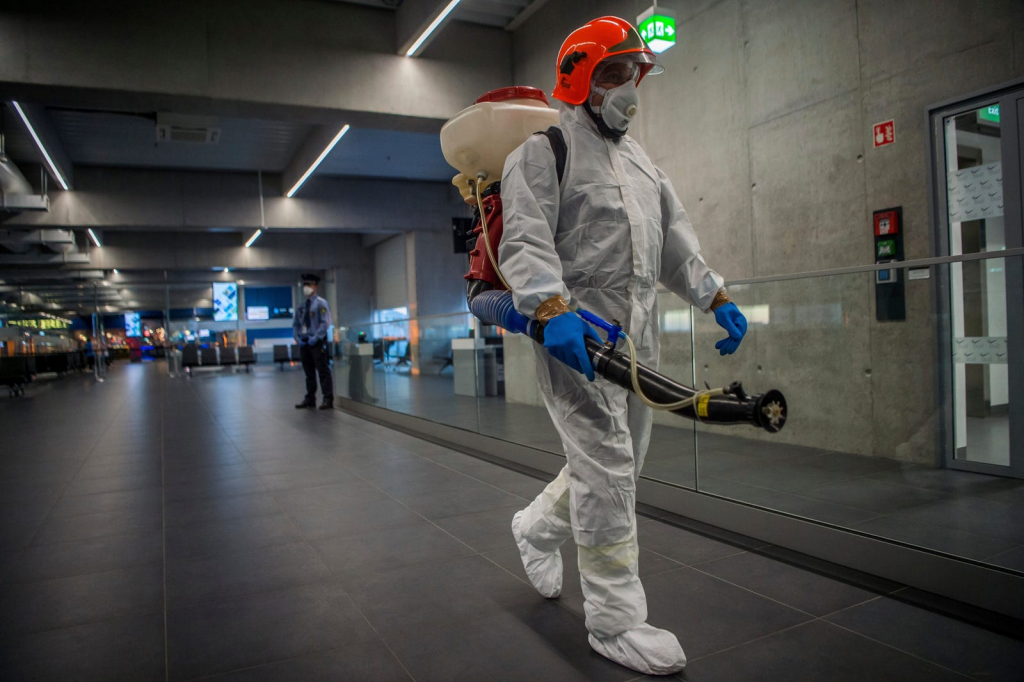 A worker carrying disinfection equipment at Budapest International Airport. Photo via Associated Press.