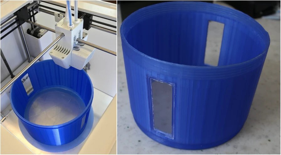 The 3D printing process of the chamber part with the viewing ports. Right: Photograph of the 3D printer during printing the chamber part with the two plexiglass windows glued in place. Image via 3D Printing in Medicine.