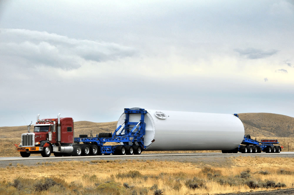 Transporting wind turbine towers is a costly and delicate operation. Photo via North East Windmills.