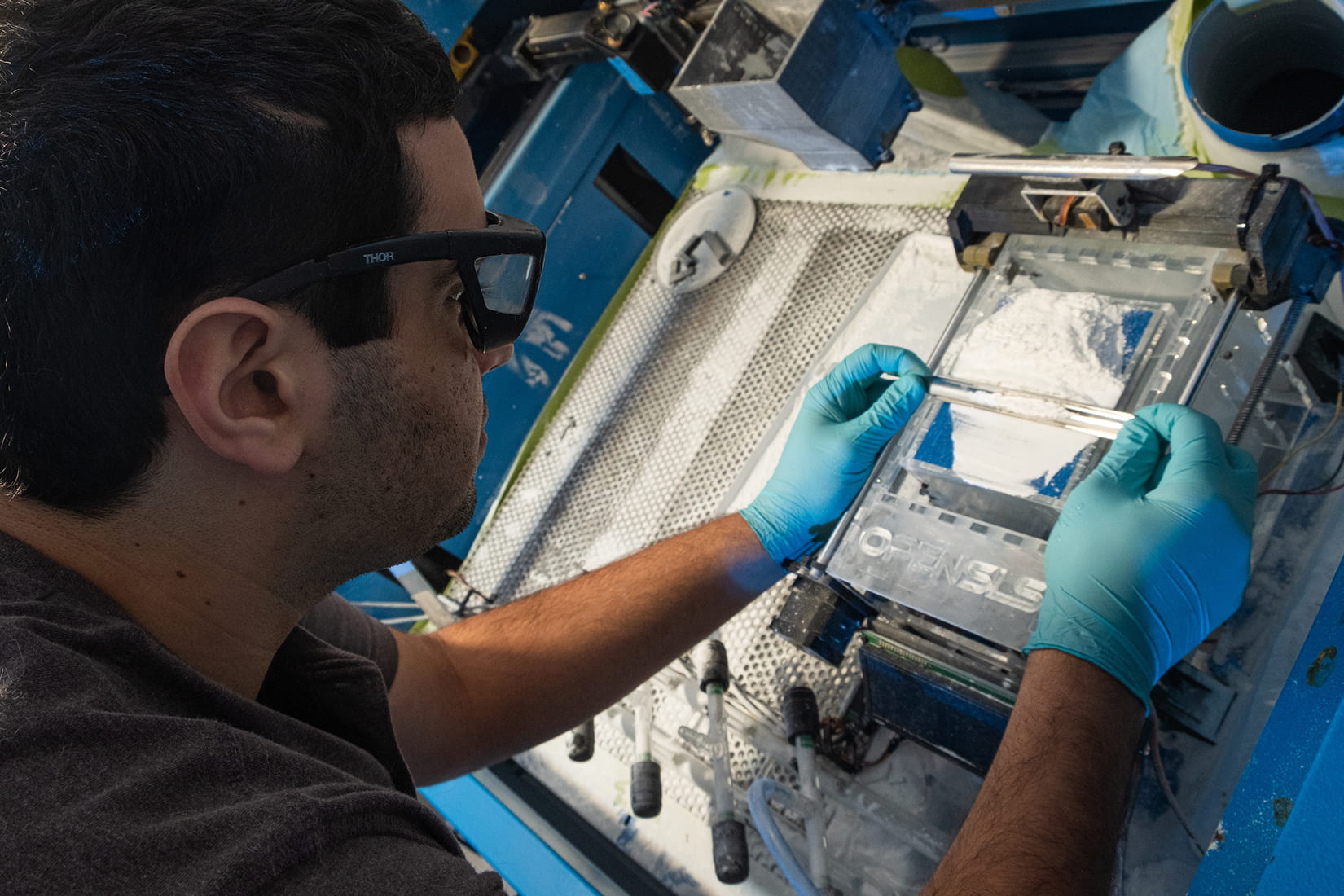 Graduate student Ian Kinstlinger preparing the selective laser sintering system in the Miller bioengineering lab at Rice University (pictured). Photo via Rice University.