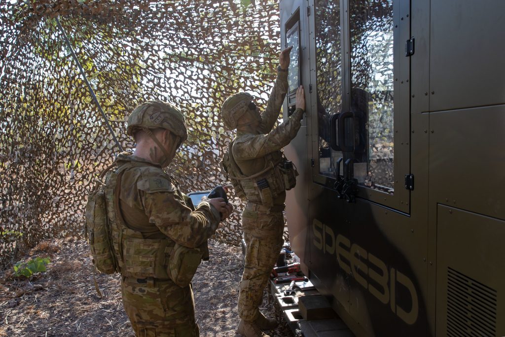 Australian Army Lance Corporal Sean Barton (right) and Craftsman Naythan Ryan, from the 1st Combat Service Support Battalion, preparing the WarpSPEE3D printer for operation. Photo via the Australian Army.