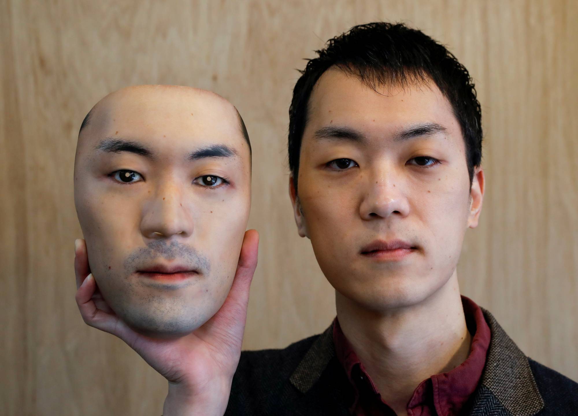 Shuhei Okawara, 30, holding a mask of his own face. Photo via Shuhei Okawara.