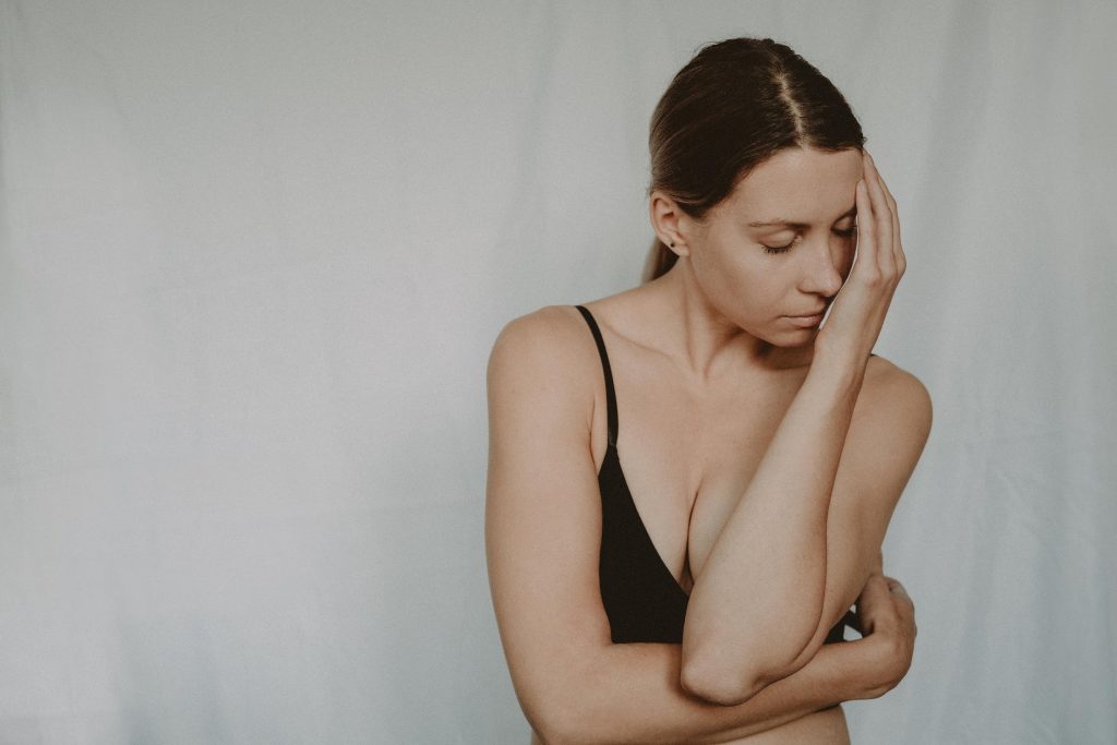 A stock photo of a woman in discomfort. Image via Anete Lusina, Pexels. 