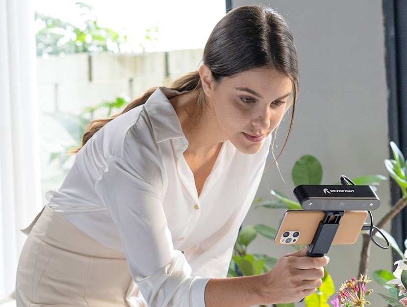 A woman using Revopoint 3D's POP 2 3D scanner. 