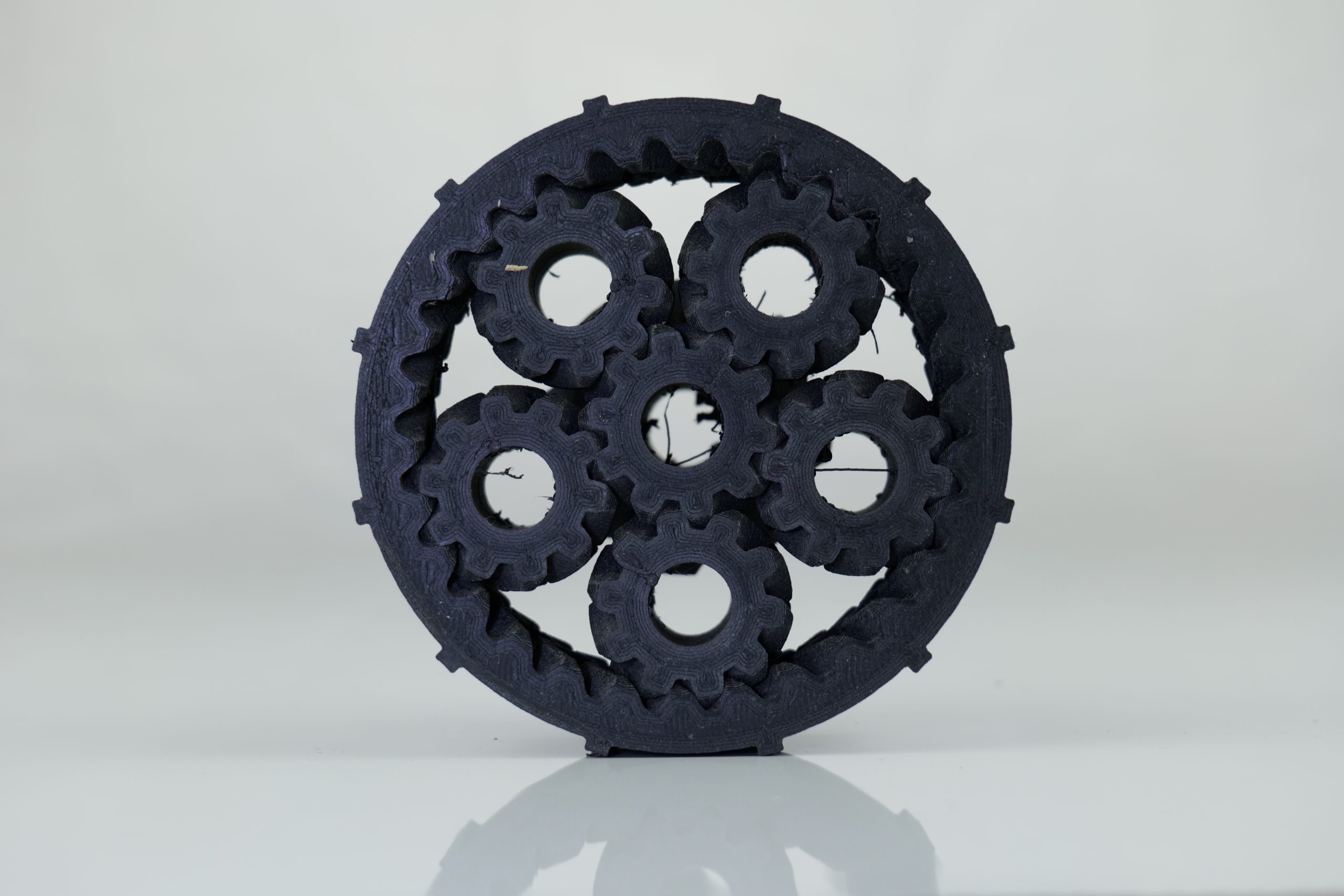 PA-CF print tests: speaker wedge, bicycle helmet, planetary gear system. Photos by 3D Printing Industry.