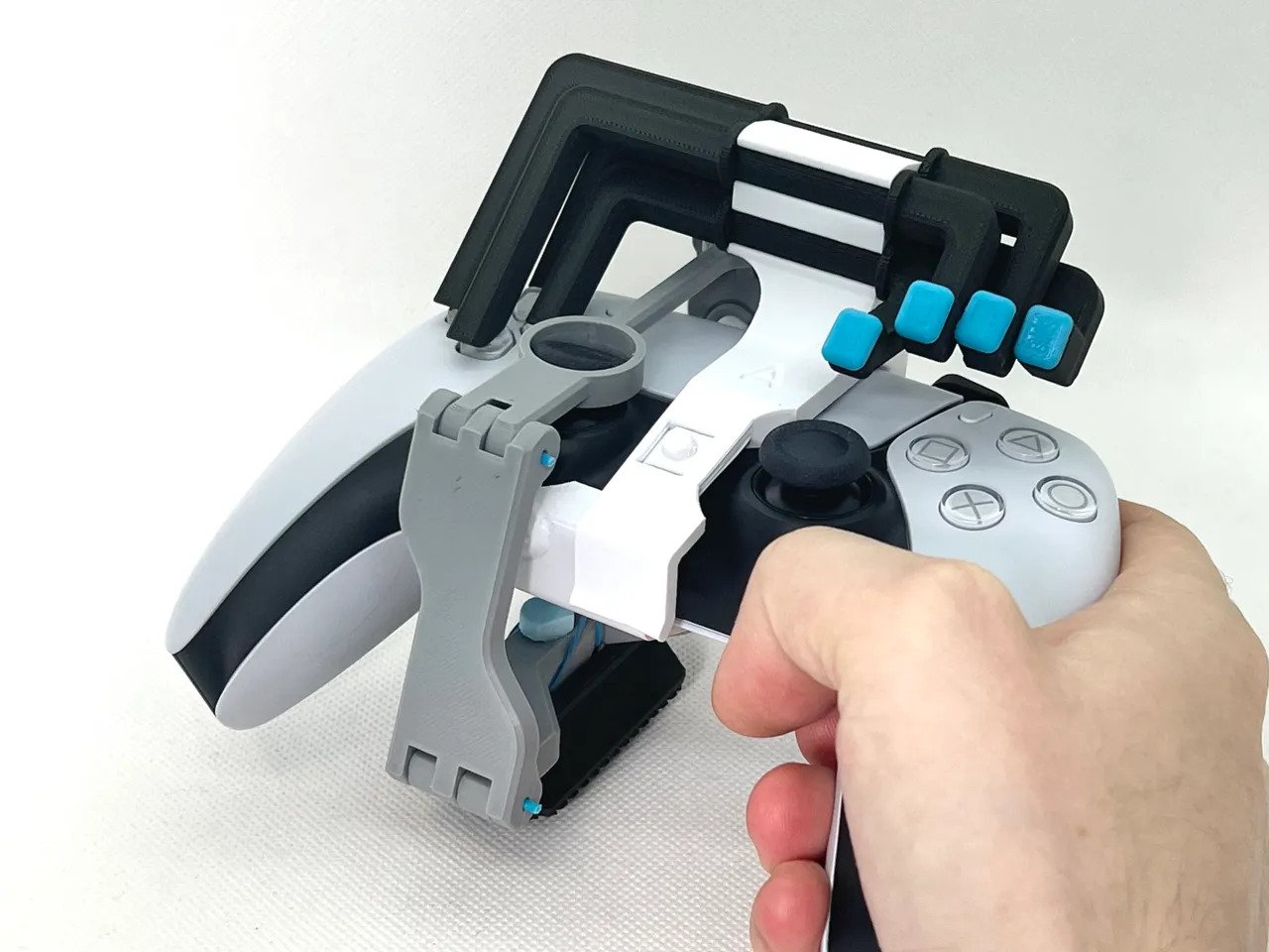 Both 3D printed adaptors combined on a PS5 DualSense controller. Photo via Akaki Kuumeri/Prusa Printers.