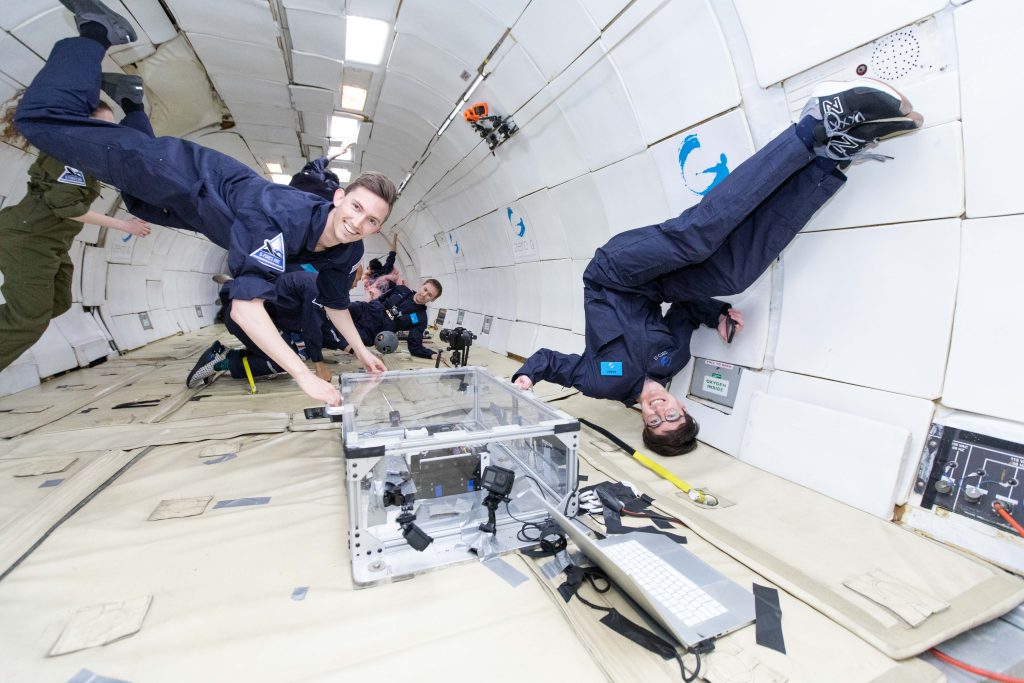 The team testing their 3D printed cubes in microgravity conditions. Photo via MIT.