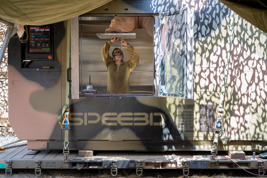An engineer setting up SPEE3D's deployable expeditionary 3D printing module.