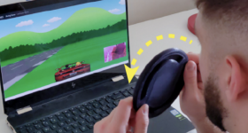 A researcher playing a game with a 3D printed steering wheel controller.