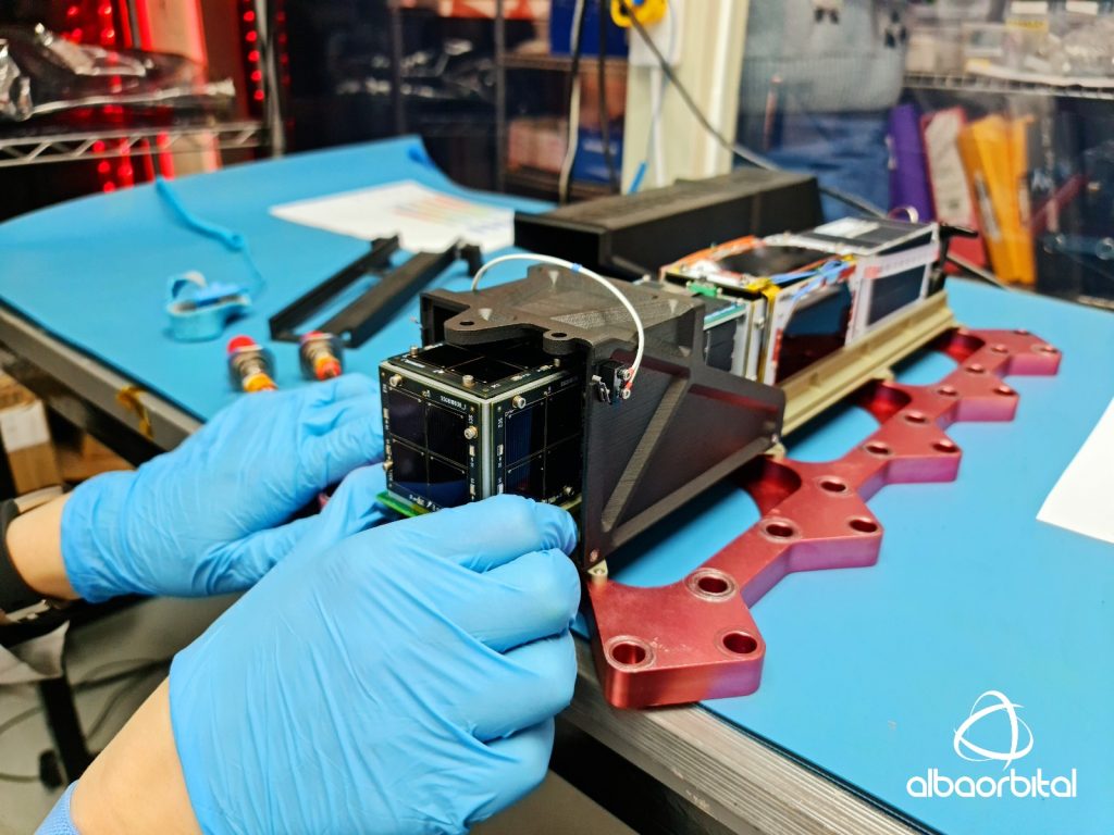 The 3D printed AlbaPod 2.0 on a vibration table going through pre-flight certification. Photo via Alba Orbital.