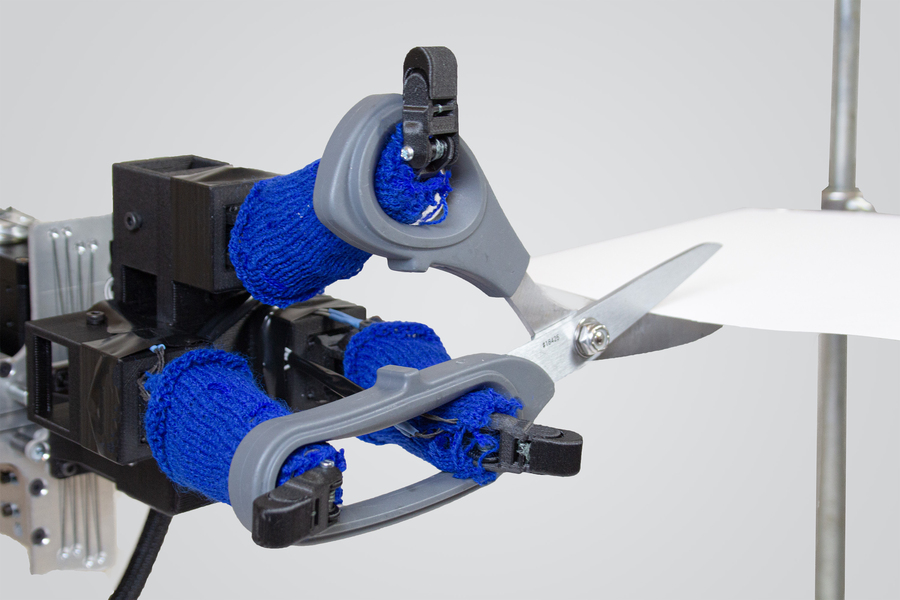 Jedna z wydrukowanych w 3D robotycznych rąk MIT, które potrafią ciąć papier nożyczkami.  Obraz za pośrednictwem MIT.