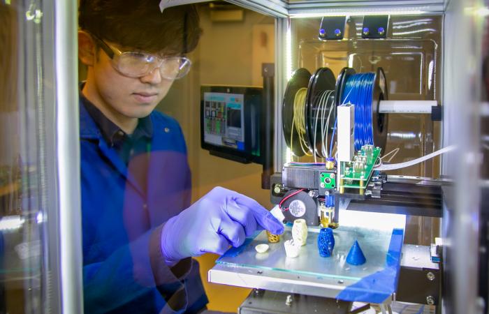 The ORNL's Sunjin Kim 3D printing using a 'vitrimer.' Photo via Genevieve Martin/ORNL, U.S. Dept. of Energy.