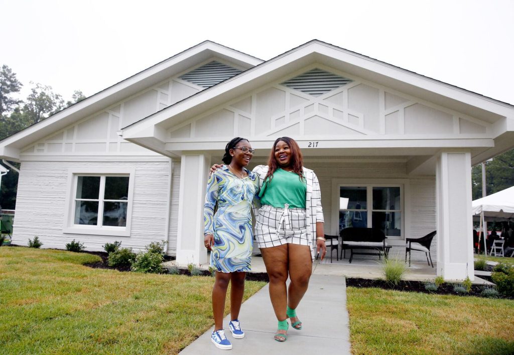 Tiffany Terrell and her daughter outside their new 3D printed home. Photo via the Richmond Times Dispatch. 