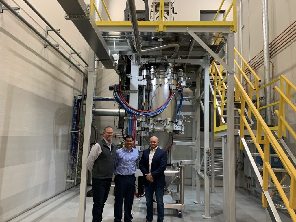 Martin and Roberts alongside 6K's VP of Technology, Jamie Perozzi, and a UniMelt reactor. Photo by Paul Hanaphy. 
