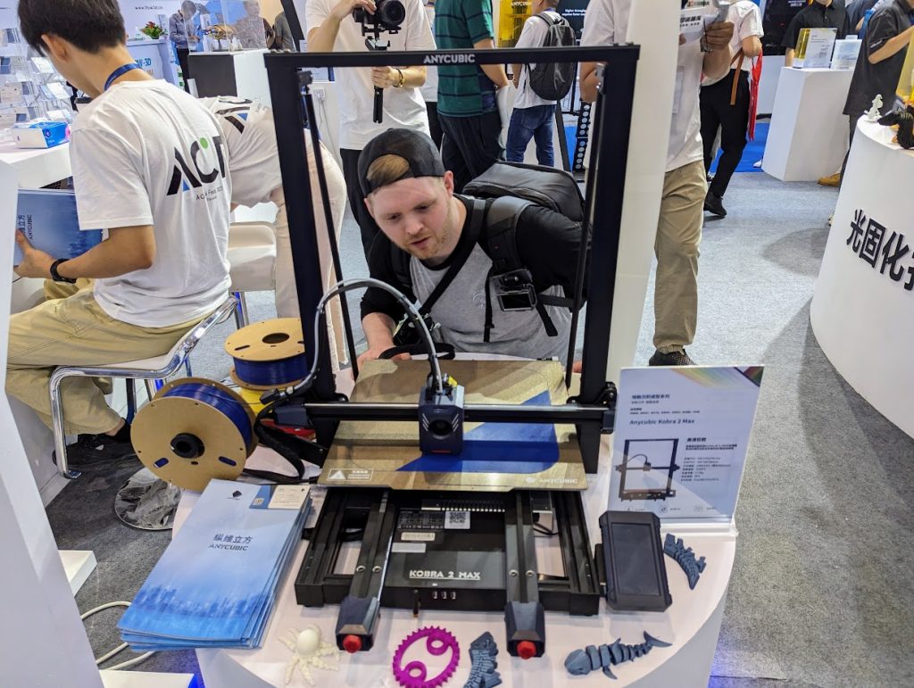 Itsboyinspace, a 3D printing influencer, at the Anycubic booth. Photo by Michael Petch.