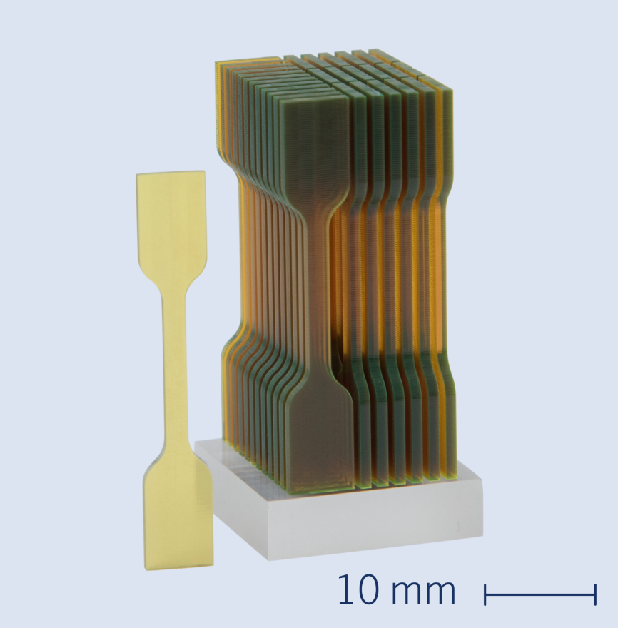 Breakthrough in the material characterization of micro-components – ISO-standard test specimens for tensile material testing, with a height of 35mm, printed using the NanoOne 2PP 3D printing platform by UpNano. Photo via UpNano.