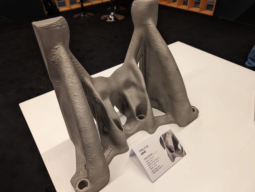 Engine bracket 3D printed on the Meltio M600, on display at AMUG 2024. Photo by 3D Printing Industry.