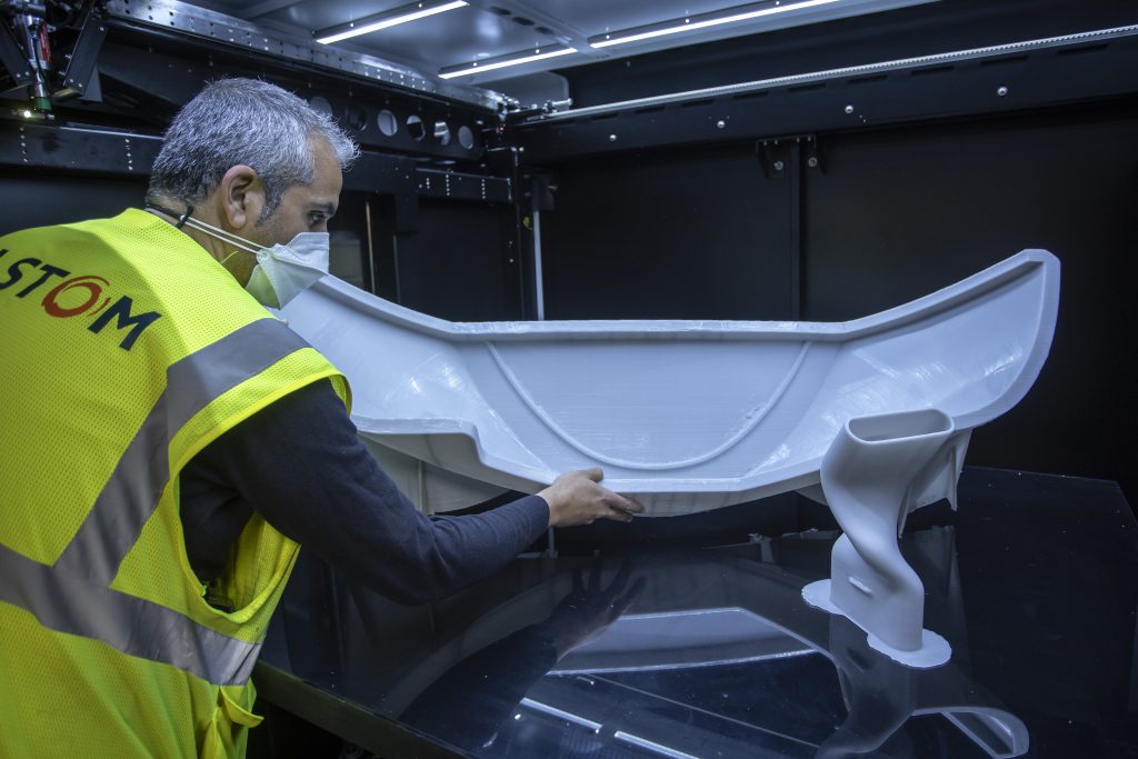 کارمند آلستوم که روی یک قطعه پرینت سه بعدی کار می کند.  عکس از طریق Alstom