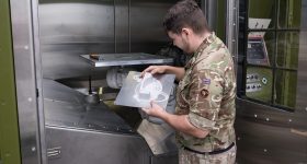 An operator checking the manufactured part after 3D printing is complete. Photo via the British Army.
