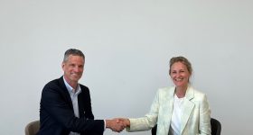 Scott Keeney (left), CEO of nLight, and Marie Langer, CEO of EOS shake hands on the agreement. Photo via EOS.